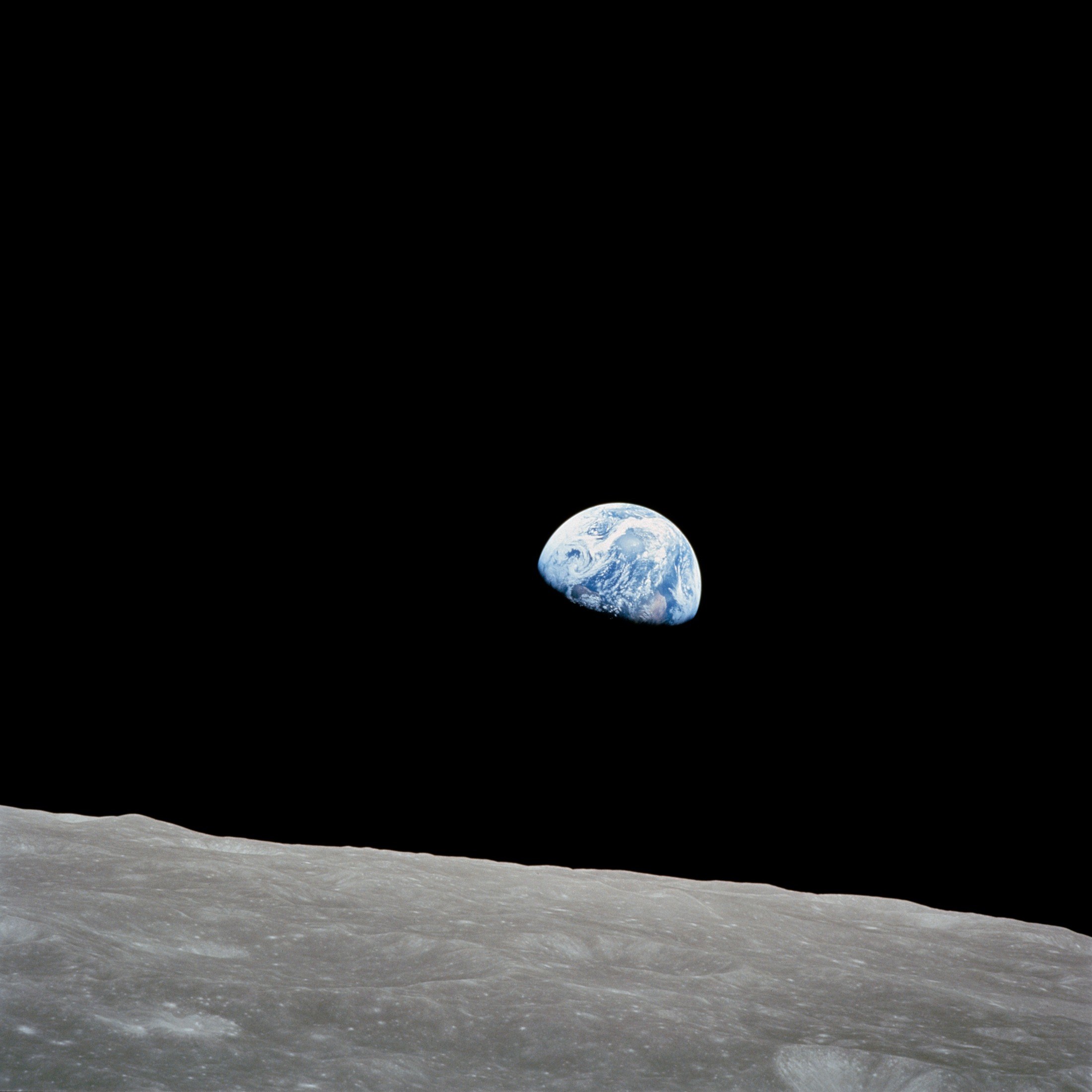 La Tierra pequeña y azul sobre el horizonte gris de la Luna.